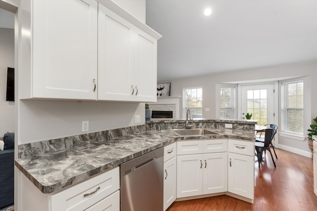 33172 Swallow Dr, Rockwood, MI 48173 - kitchen featuring light wood finished floors, a peninsula, stainless steel dishwasher, a sink, and white cabinetry