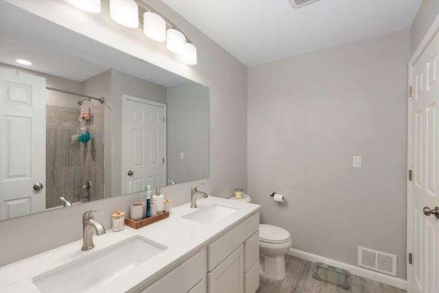 33172 Swallow Dr, Rockwood, MI 48173 - bathroom featuring toilet, a sink, visible vents, and tiled shower
