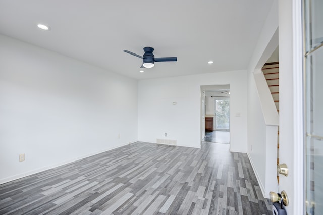 empty room with ceiling fan, recessed lighting, stairway, and wood finished floors