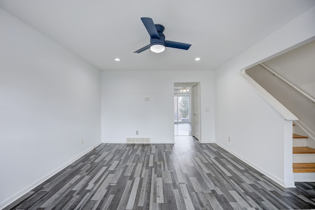 spare room featuring visible vents, baseboards, stairs, ceiling fan, and wood finished floors