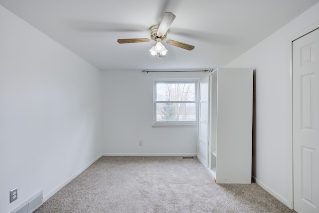 unfurnished bedroom with carpet flooring, baseboards, ceiling fan, and visible vents