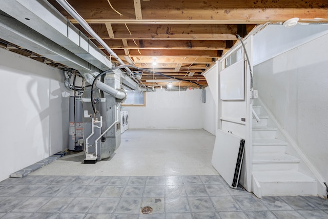 basement featuring water heater, tile patterned floors, washing machine and dryer, heating unit, and stairway