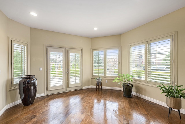 unfurnished room with dark wood-type flooring, baseboards, visible vents, and recessed lighting