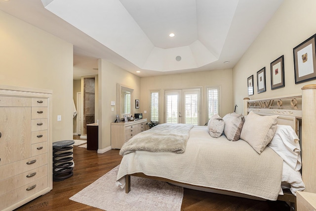 bedroom featuring a tray ceiling, recessed lighting, baseboards, dark wood finished floors, and access to exterior