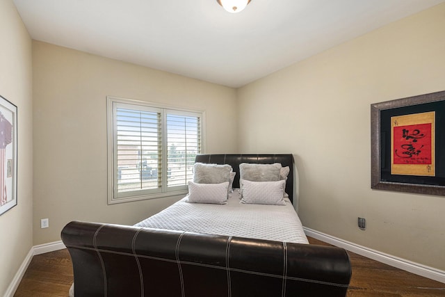 bedroom with baseboards and dark wood-style flooring