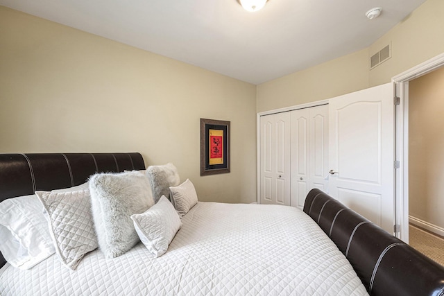 carpeted bedroom with a closet, baseboards, and visible vents