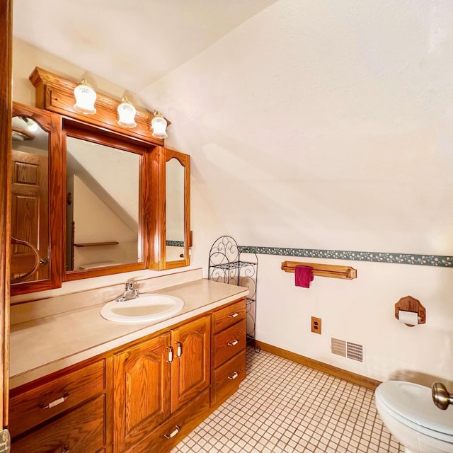 bathroom featuring visible vents, baseboards, toilet, vanity, and lofted ceiling