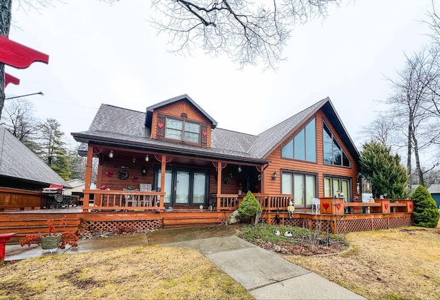 exterior space featuring a porch, french doors, and a lawn