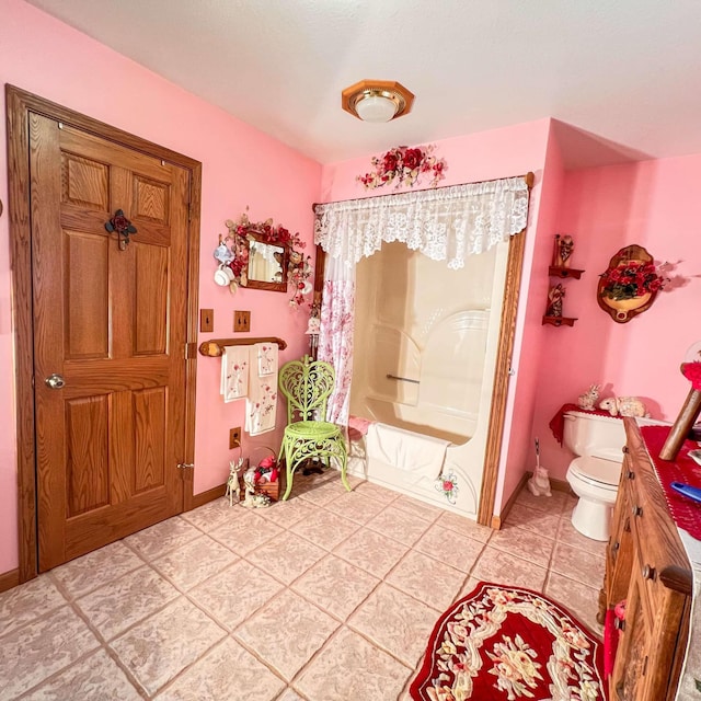 full bath featuring toilet, tile patterned floors, and baseboards