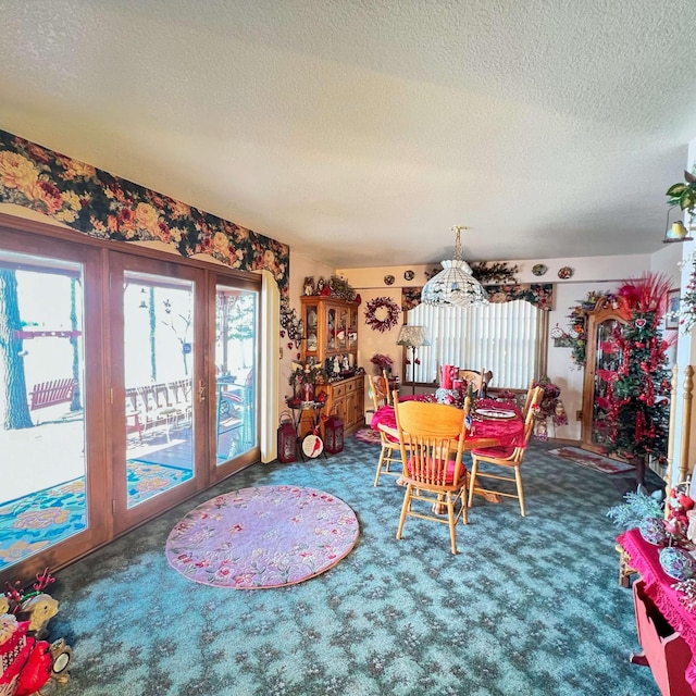 dining space featuring french doors, carpet flooring, a chandelier, and a textured ceiling