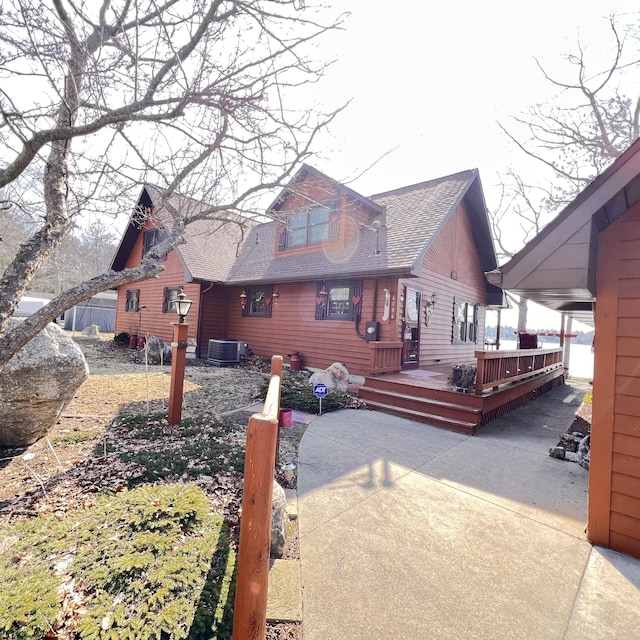 view of property exterior with central AC unit, a shingled roof, and a deck