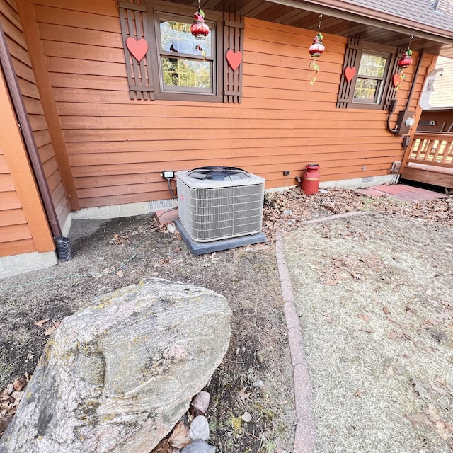 exterior details with electric meter, central AC unit, and crawl space