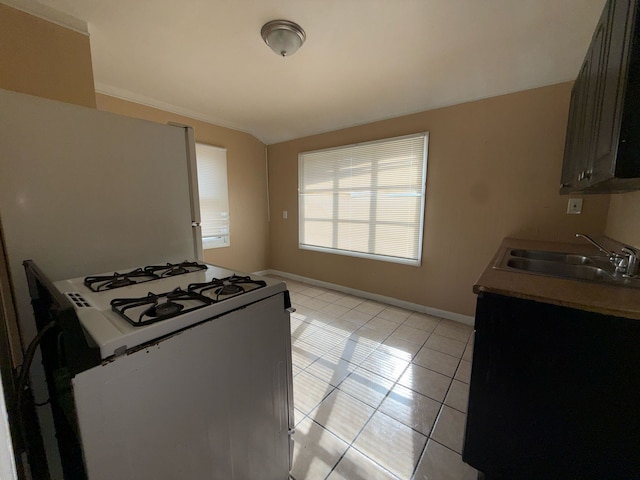 20561 Alcoy St, Detroit, MI 48205 - kitchen with a sink, lofted ceiling, light tile patterned flooring, baseboards, and white gas range oven
