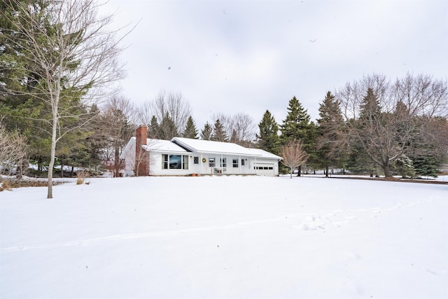 view of front of house with an attached garage and a chimney