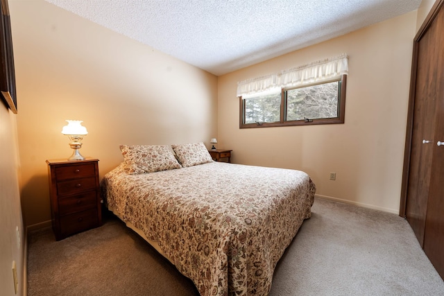 carpeted bedroom with a closet, a textured ceiling, and baseboards