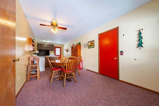 carpeted dining area featuring a ceiling fan, baseboards, and a textured ceiling