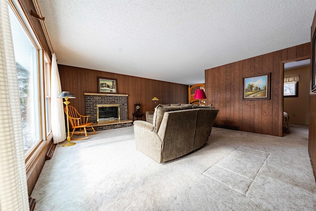 carpeted living room with wood walls, a fireplace, and a textured ceiling