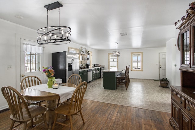 31585 Michigan Ave, Leonidas, MI 49066 - dining space with an inviting chandelier, baseboards, wood finished floors, and visible vents