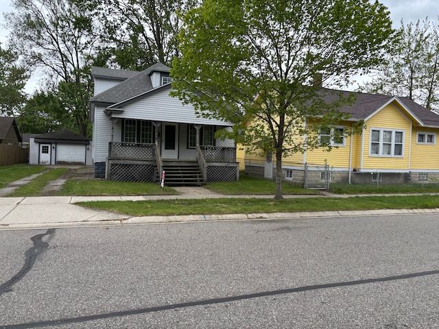 1720 White St, Port Huron, MI 48060 - bungalow-style house with covered porch, a garage, an outdoor structure, roof with shingles, and driveway