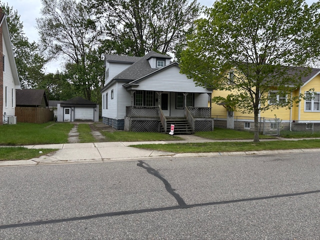 1720 White St, Port Huron, MI 48060 - bungalow-style house featuring a porch, an outbuilding, a garage, roof with shingles, and driveway
