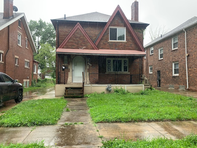 14839 Rutherford St, Detroit, MI 48227 - tudor-style house featuring a chimney, a porch, and brick siding