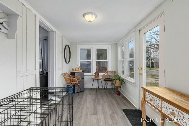 sunroom with baseboards and wood finished floors