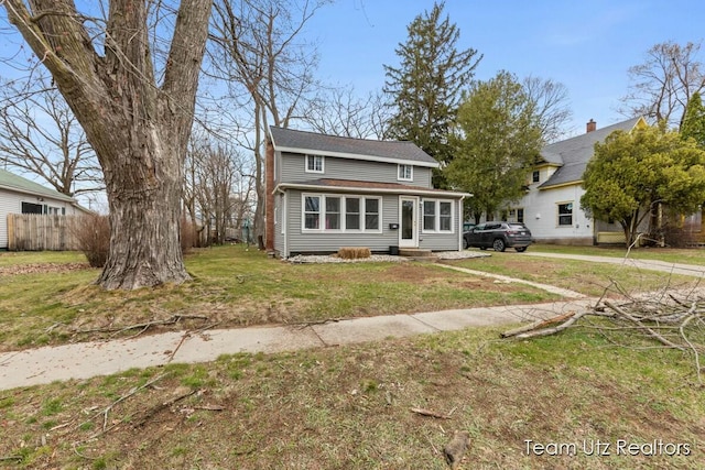 view of front facade featuring fence, a front yard, and entry steps