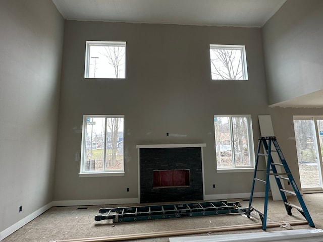 workout room featuring a towering ceiling and plenty of natural light