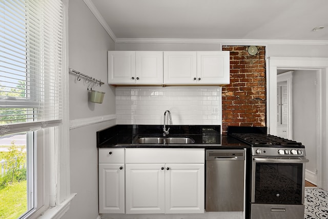 kitchen featuring appliances with stainless steel finishes, a sink, crown molding, white cabinets, and decorative backsplash