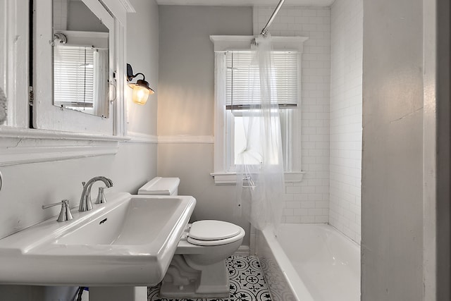 bathroom with a sink, toilet, tile patterned flooring, and washtub / shower combination