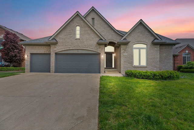 18277 Crenshaw Dr, Macomb, MI 48042 - french provincial home with a yard, brick siding, concrete driveway, and a garage