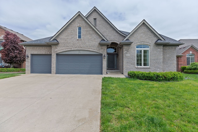 18277 Crenshaw Dr, Macomb, MI 48042 - french country home with brick siding, a front yard, driveway, and a garage