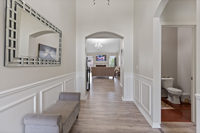 18277 Crenshaw Dr, Macomb, MI 48042 - hallway with arched walkways, wood finished floors, a wainscoted wall, and a decorative wall