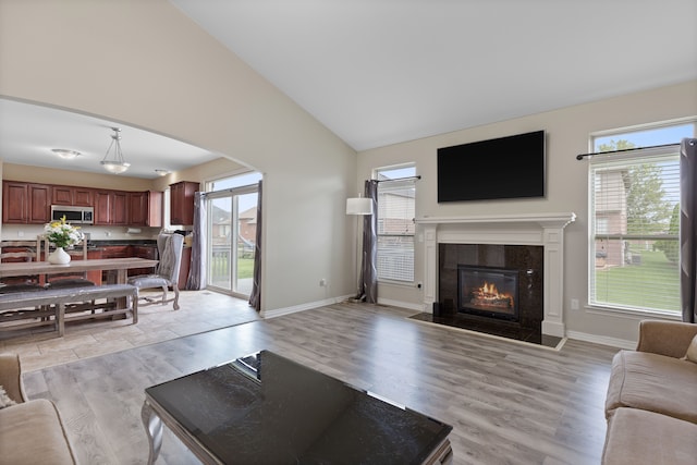 18277 Crenshaw Dr, Macomb, MI 48042 - living area featuring vaulted ceiling, healthy amount of natural light, arched walkways, and a fireplace with flush hearth