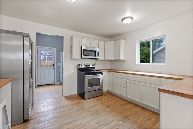 142 E Glass Rd, Ortonville, MI 48462 - kitchen with butcher block countertops, white cabinets, stainless steel appliances, and light wood-style floors