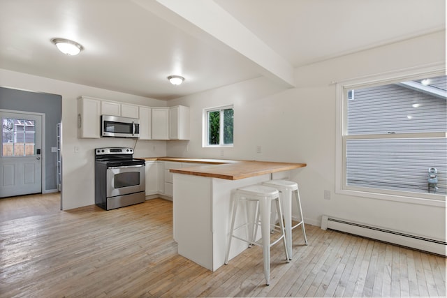 142 E Glass Rd, Ortonville, MI 48462 - kitchen featuring a kitchen breakfast bar, light wood finished floors, butcher block counters, appliances with stainless steel finishes, and baseboard heating