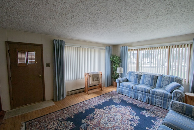 living area with a baseboard radiator, a textured ceiling, and hardwood / wood-style floors