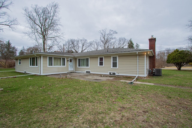 view of front of house featuring cooling unit, a chimney, a front lawn, and a patio area