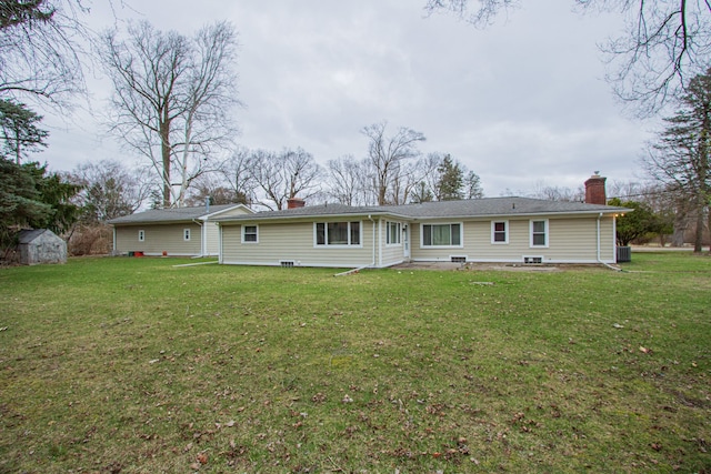 back of house featuring an outdoor structure, a storage shed, central AC, a yard, and a chimney
