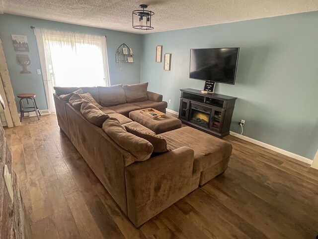 6201 E Holly Rd, Holly, MI 48442 - living area with a textured ceiling, baseboards, and wood finished floors