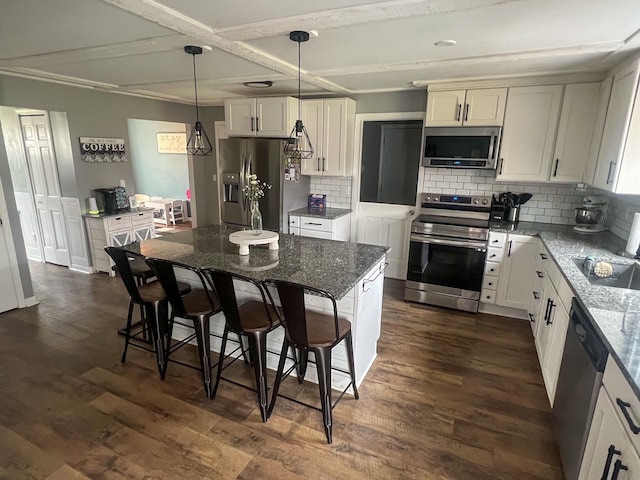 6201 E Holly Rd, Holly, MI 48442 - kitchen with dark wood-style flooring, stainless steel appliances, dark stone countertops, and a kitchen bar