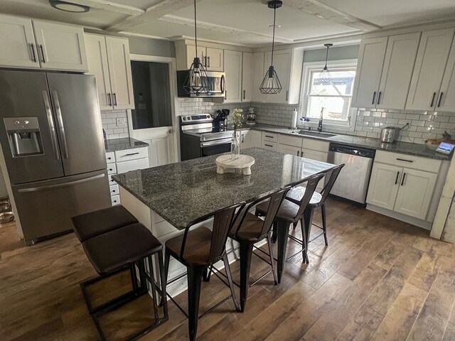 6201 E Holly Rd, Holly, MI 48442 - kitchen featuring stainless steel appliances, tasteful backsplash, dark wood-type flooring, a sink, and hanging light fixtures