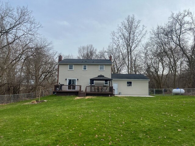 6201 E Holly Rd, Holly, MI 48442 - rear view of house featuring a fenced backyard, a chimney, a deck, and a lawn