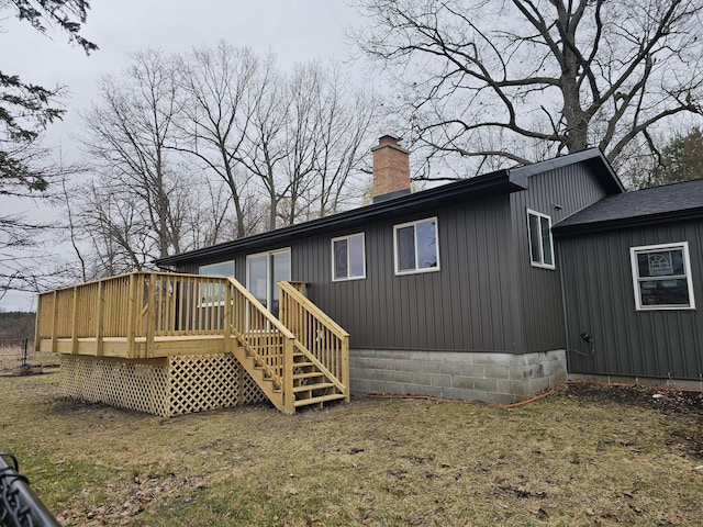 back of property with a wooden deck and a chimney