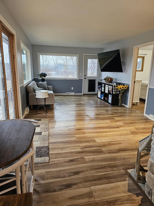 living room with visible vents, baseboards, and wood finished floors