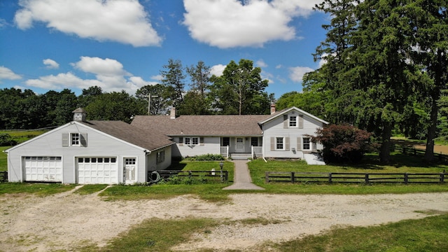 8162 Groveland Rd, Holly, MI 48442 - view of front of property with a porch, a garage, a chimney, driveway, and view of scattered trees