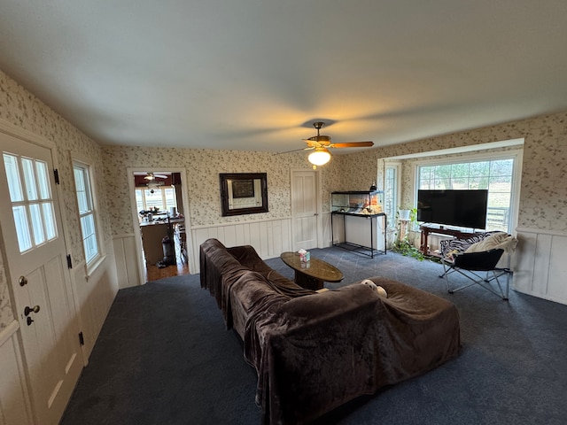 8162 Groveland Rd, Holly, MI 48442 - living area with wallpapered walls, wainscoting, a ceiling fan, and dark carpet