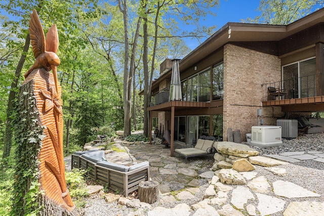 403 Riverview Dr, Ann Arbor, MI 48104 - back of house featuring brick siding, central air condition unit, and a patio