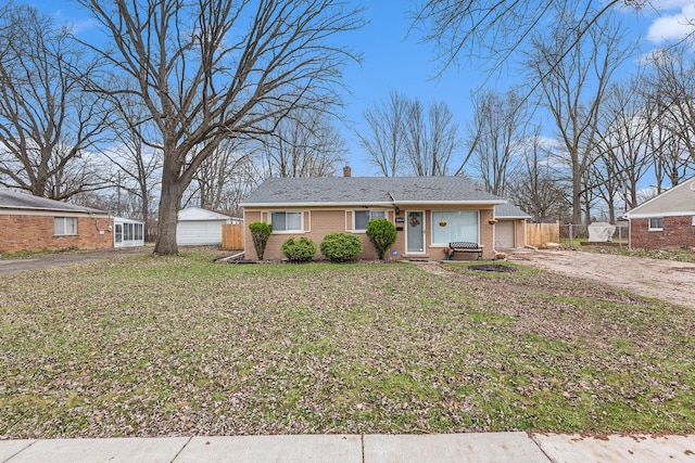 view of front facade with driveway, a front yard, fence, and a garage