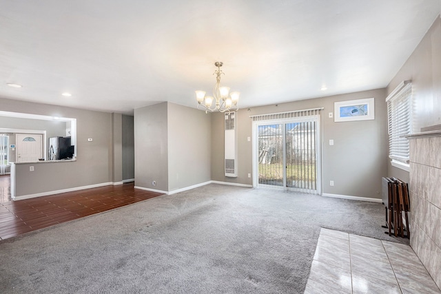 unfurnished living room with carpet flooring, baseboards, a chandelier, and recessed lighting